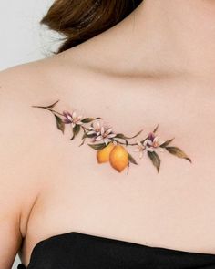 a woman's chest with an orange and flowers tattoo on her left side shoulder