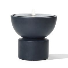 a black candle holder sitting on top of a white surface