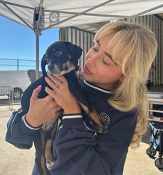 a woman holding a small dog in her arms