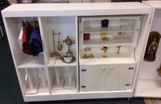 a white cabinet filled with lots of gold and silver items on it's sides