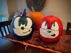 two painted pumpkins sitting on top of a table