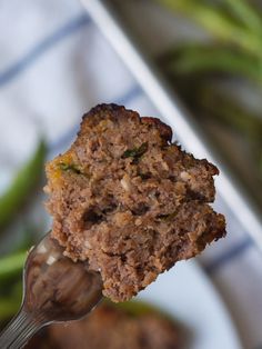 a piece of meatloaf on a fork with green beans