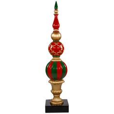 a red, green and gold christmas ornament on a black stand with a white background