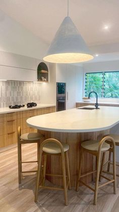 an island in the middle of a kitchen with three stools and a counter top