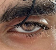 the eye of a man with long black hair on top of his head and eyebrows