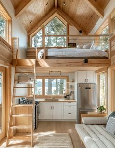 a loft bed sitting in the middle of a living room next to a kitchen and dining area