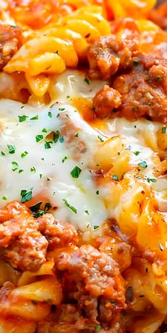 a close up of a plate of pasta with meat and cheese on it, topped with parsley