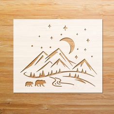 a wooden cutout with mountains, stars and bears in the night sky on a wood background