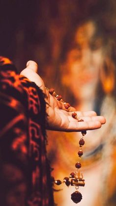 a woman holding out her hand with beads on it