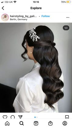 the back of a woman's head with long dark hair and flowers in her hair