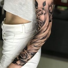 a woman's arm with flowers and leaves on it