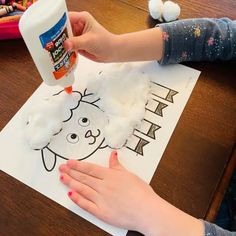 a child is making a drawing with cotton balls