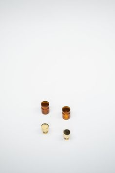 three wooden cups sitting next to each other on a white surface with one cup in the middle