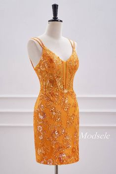 a mannequin is dressed in an orange dress with gold sequins on it