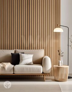 a white couch sitting next to a wooden wall