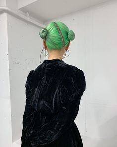 a woman with green hair in a black dress