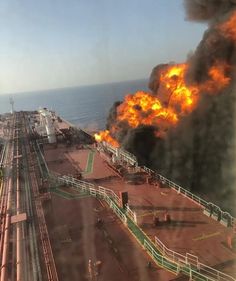 an oil rig on fire near the ocean