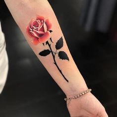 a woman's arm with a rose tattoo on it