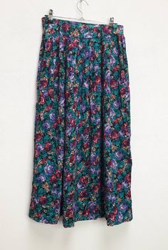 "a vintage green and purple floral high-waisted long skirt ✿ IMPORTANT INFORMATION: * excellent vintage condition * material: 100% rayon * size: extra-small - please check exact measurements below (they're there for your benefit!) * garment care: machine washable * made in the u.s.a. ✿ MEASUREMENTS (taken while item is lying flat, some measurements will need to be doubled): * length: 31\" (79cm) * waist: 12.5\" (32cm) * hips: 29\" (74cm) ✿ free UK shipping on orders over £100 with code STRAWBERR Green Flared Maxi Skirt With Floral Print, Green Floral Print Flowy Skirt, Green Floral Print Midi Skirt, Vintage Green Long Skirt, Green Flared Skirt With Floral Print, Vintage Green Tiered Skirt, Vintage Long Green Skirt, Green Vintage Long Skirt, Green Floral Print Tiered Skirt