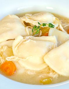 a white bowl filled with dumplings and carrots