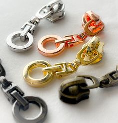 several different colored metal chains on a white surface