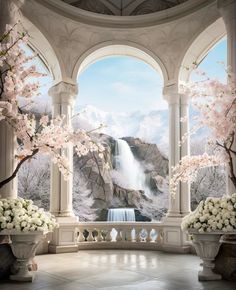 a large room with an arched window and flowers in vases on the floor, overlooking a waterfall