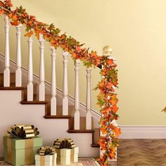 a staircase decorated with fall leaves and presents under the bannister next to it