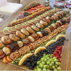 a long table filled with lots of different types of sandwiches and fruit on top of it