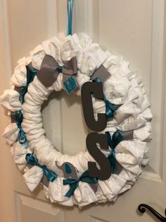 a wreath made out of diapers hanging on a door with the number twenty five