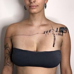 a woman with tattoos on her chest posing for the camera