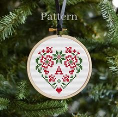 a cross stitch heart ornament hanging on a christmas tree with the words pattern