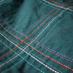 closeup of the stitchs on a green shirt