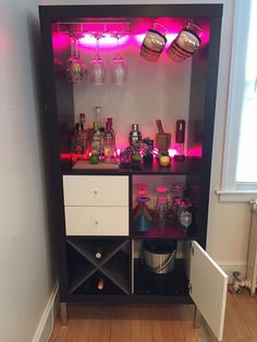 a cabinet with many bottles and glasses on it