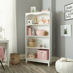 a white book shelf in a room with grey walls and wooden flooring on the side