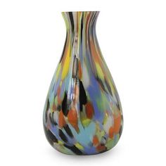 a multicolored glass vase sitting on top of a white table next to a lamp