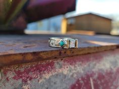 a couple of rings sitting on top of a rusted metal table next to a building