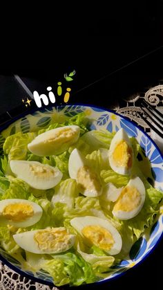 a blue and white plate topped with lettuce and hard boiled eggs