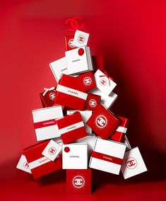 a christmas tree made out of red and white boxes with the word chanel on it