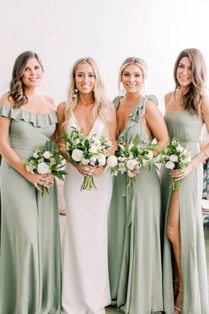 bridesmaids in sage green dresses with white flowers and greenery on the side