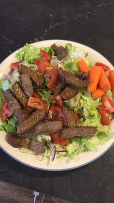 a white plate topped with meat and veggies