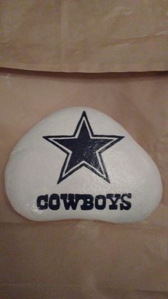 a white and black rock with the word cowboys on it