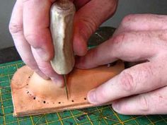 a man is carving something on a piece of wood with a knife and some sort of tool