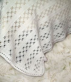 a white crocheted blanket laying on top of a furnishing covered floor