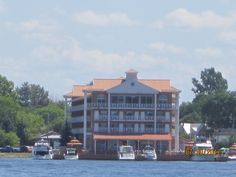 a large building sitting on the side of a lake next to a boat dock with several boats parked in front of it