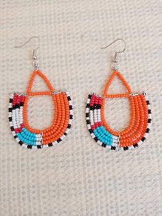 Circle Earrings | Custom Earrings | Hoop Earrings | Dainty Earrings | Beaded Earrings | Moms Gift | Gift Ideas | Unique Gift These eye catching  earrings are superbly crafted and can be worn with any outfit.The earrings are very light to wear.Main Color - multi color.The earrings measure 3 inches from top of the hook.**Buy multiple items and pay shipping for 1 item only.The rest ships free.Feel free to send me a convo or e-mail for any clarification or wholesale pieces.Thank you for visiting... Artisan Orange Beaded Earrings, Artisan Handmade Wrap Drop Earrings, Handmade Artisan Dangle Wrap Earrings, Handmade Orange Hoop Earrings, Artisan Orange Round Bead Earrings, Orange Hoop Beaded Earrings As Gift, Orange Hoop Earrings With Colorful Beads For Gift, Orange Small Hoop Bohemian Earrings, Artisan Beaded Hoop Earrings