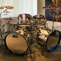 a close up of a drum set on a carpeted floor in front of a window