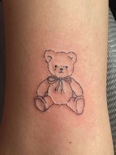 a small teddy bear tattoo on the ankle