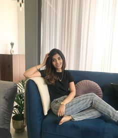 a woman sitting on top of a blue couch