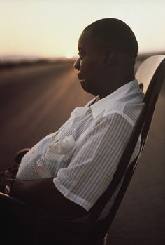 a man sitting in a chair with the sun behind him