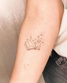 a woman's arm with a book and stars tattoo on the left side of her arm